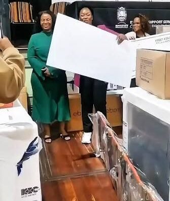 People smiling while holding a white board